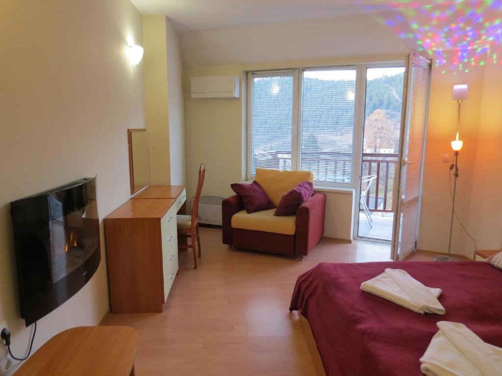 Панорамен апартамент 301 - Луксозна мастър спалня с камина, фотьойл и панорамен изглед към гората